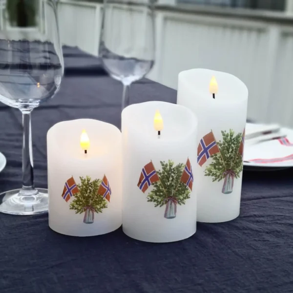 17.mai-lys-produkt-1-dekorio Bilde av tre Kubelys med 17.mai tema merker oppå et pent tildekket serveringsbord. Dekorio i samarbeid med UndrumDesign i laging av nettside.